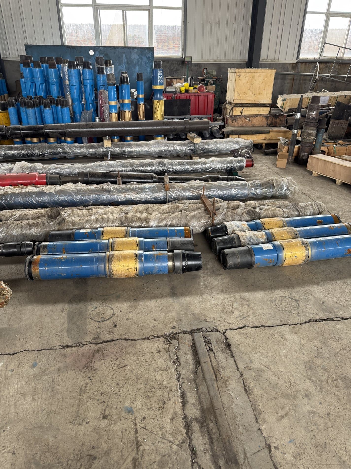 Blue and yellow long drilling tools in a workshop