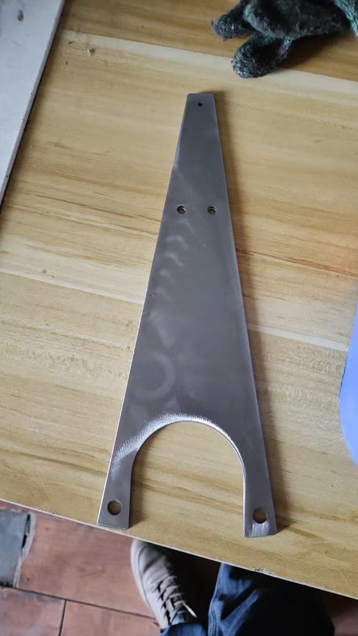 Flat metal bracket with mounting holes and a large curved opening