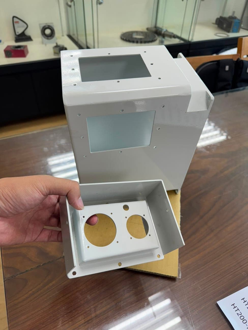 White coated machine enclosure and a smaller housing with circular cutouts
