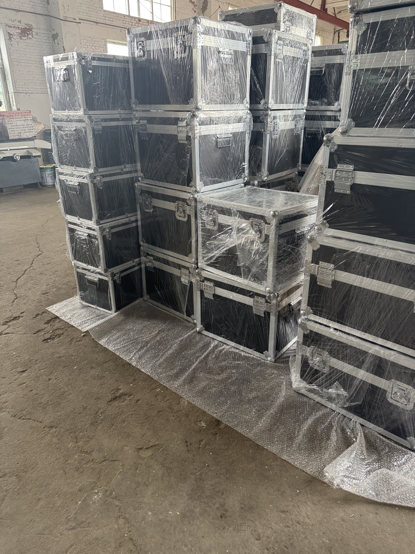 Stacked black transport cases with metal frames and protective wrapping