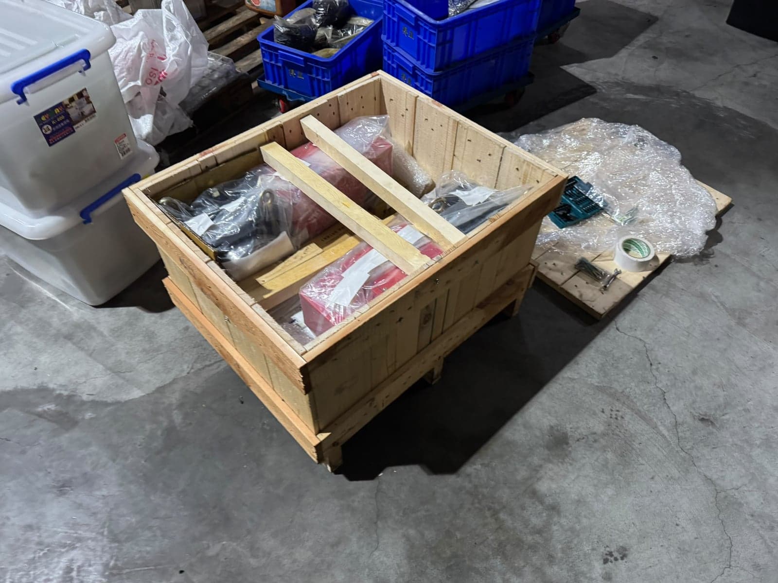 Open wooden crate with individually wrapped items and wooden internal braces before closing