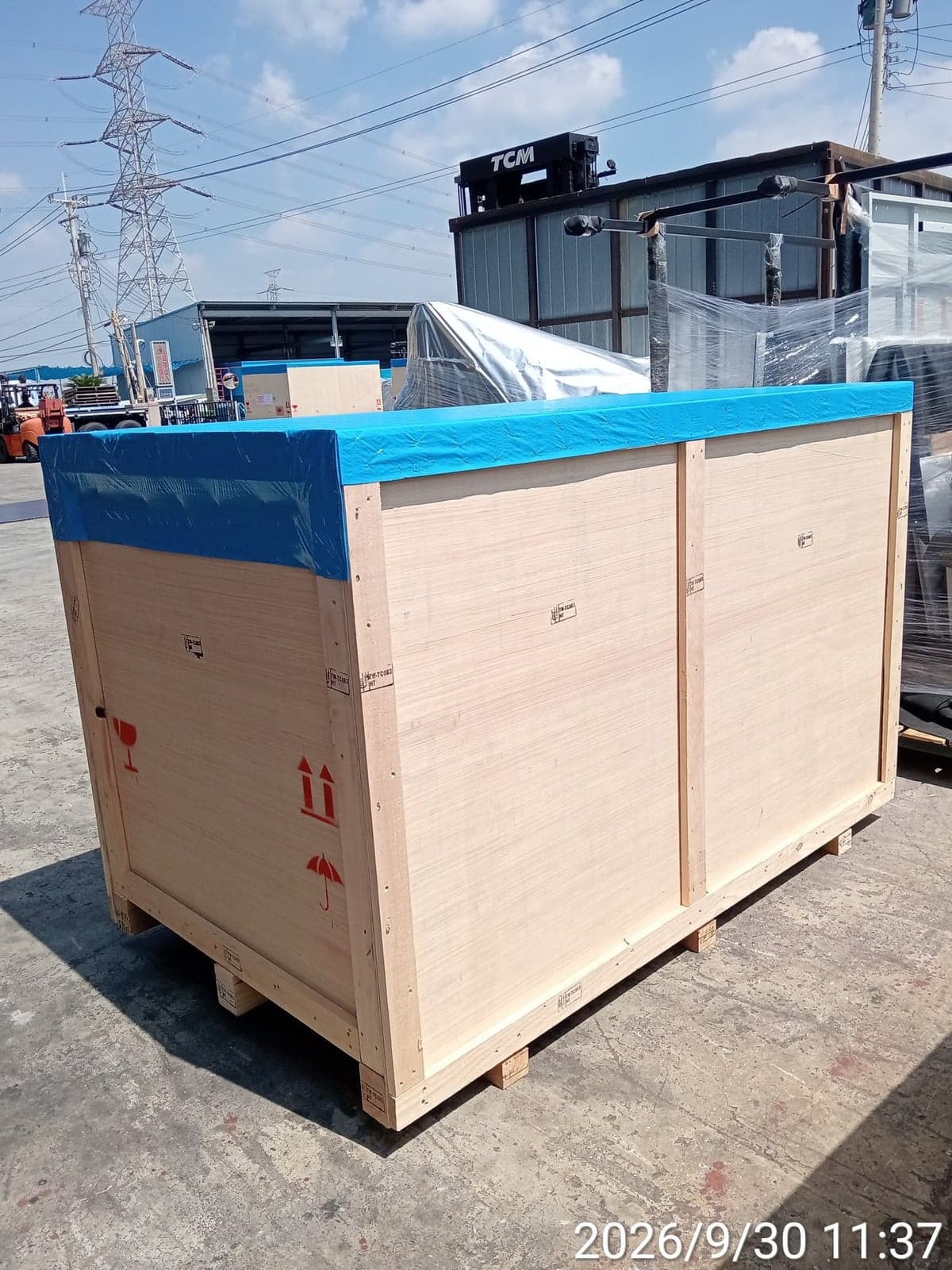 Completed wooden export crate with a blue top cover, pallet base and handling symbols
